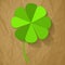 Four Leaf Clover on a crumpled paper brown background.