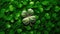 Four-leaf clover is sitting on top of bed of green grass. The clover has been polished and shines, adding to its