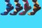 Four legs in socks with a pattern of colored rhombuses, on a turquoise background, concept