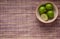 Four limes in a cup on mat background