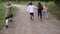four little girls sisters happy playing in the summer park holding hands and running view from the back