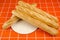 Four loaves on a wooden tray on an orange background