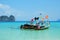 Four long tail boats are floating on the Sea. Background of photo is mountains and blue sky. Itâ€™s summer in Thailand.