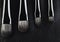 four makeup brushes close-up on a textured black leather background. horizontal