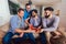 Four male friends eating pizza at home