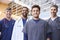 Four male healthcare colleagues standing outdoors, portrait