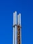 Four metal pipes against a blue sky