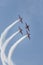 Four military jets synchronously flying up in the blue sky and performing a show leaving smoke marks