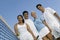 Four mixed doubles tennis players at net on tennis court portrait low angle view