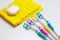 Four multicolored toothbrushes and dental floss over white background