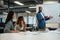 Four multiracial business people in businesswear talking and gesturing during meeting in office