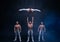 Four muscular man perform difficult acrobatic tricks on black studio
