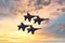 Four Navy Blue Angels against a sunset