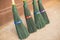 Four new brooms made of green plastic.