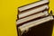 Four old diaries standing on endpaper on yellow background