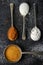 Four old spoons with brown, white, icing sugar and cocoa powder