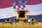 four orange combine harvesters on farm field with flag background, Croatia agriculture concept - industrial 3D illustration