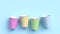 Four paper cups with different colorful patterns on blue pastel background