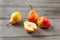 Four pears, one cut in half, on gray wood desk.