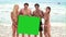 Four people holding onto a green screen
