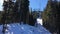 Four person ski chair lift going through the trees up a mountain with a blue sky