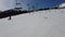 Four person ski chair lift going through the trees up a mountain with a blue sky