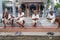 Four physically weak elderly Indians are sitting on the steps of a temple talking with each other