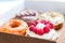 Four pieces of totally different colorful and delicious looking donuts in ecological carton box. appetising fast food dessert