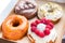 Four pieces of totally different colorful and delicious looking donuts in ecological carton box. appetising fast food dessert
