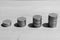 Four piles of coins on a wooden surface. Black and white photo. Business concept