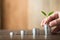 Four piles of money laid on wood, wood background, natural light, finance, interest, increase, four steps