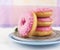 Four pink donuts on silver plate