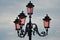 Four pink lamps on an ornate metal stand in Venice