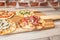 Four pizzas on a wooden board with focus in a ham pizza