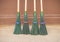 Four plastic street brooms with wooden handles