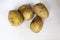 Four potatoes on a white background, view from above