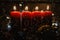 Four red Advent candles with 2022 figures on them and Christmas decorations lying in the snow as a template