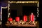 Four red candles - the first lighted candle of the first Sunday of Advent festival before Christmas with lightning chain in backgr