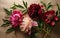 four red and pink peonies and green flora