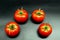 Four red ripe juicy tomatoes in a semi-circle on a black background