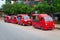 Four red taxis parked in the street.