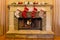 Four red and white Christmas stockings adorn a stone fireplace.