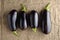 Four ripe black eggplants on linen cloth. Rustic top view