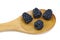 Four ripe blackberries in a wooden spoon.