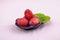 Four ripe red plums on a small dish in studio