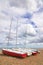 Four sailboats on a pebble beach