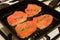 Four salmon steaks and herbs in frying pan