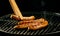 Four sausages cooking on a portable barbecue