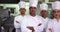 Four serious chefs looking at camera with arms crossed