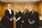 Four serious judges standing while wearing robes